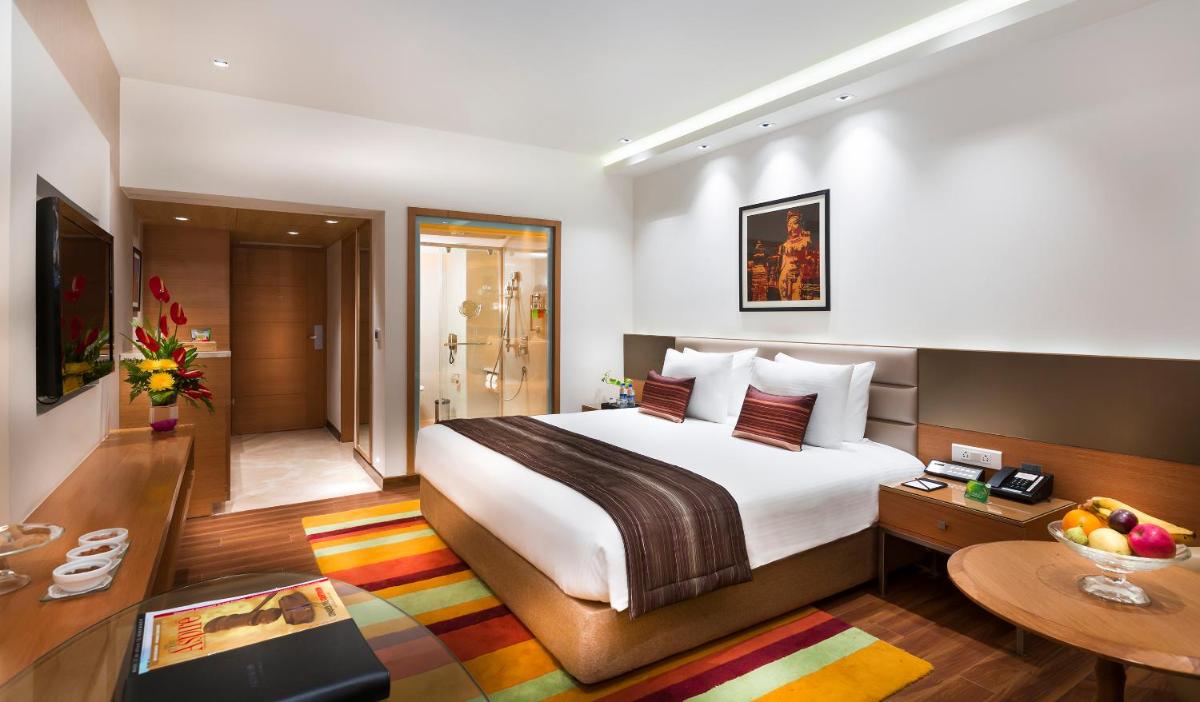 a hotel room with a bed and a table at Grand Chennai by GRT Hotels in Chennai