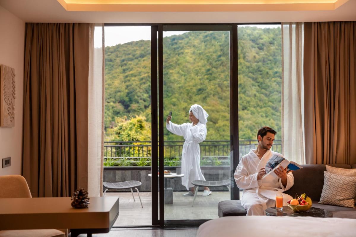 a man and woman sitting in a living room looking out the window at Hyatt Regency Dehradun Resort and Spa in Dehradun