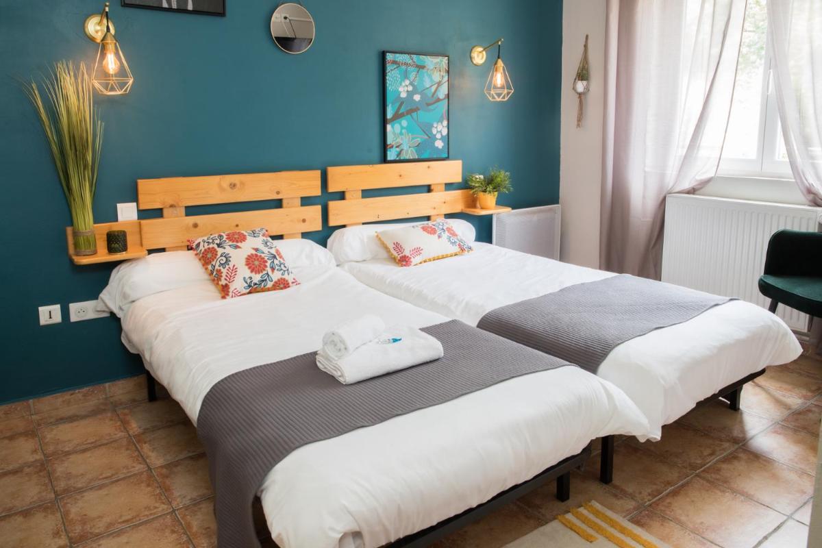 deux lits dans une chambre aux murs bleus dans l'établissement Logis hôtel restaurant Auberge de l'Espinouse, à Fraisse-sur-Agout