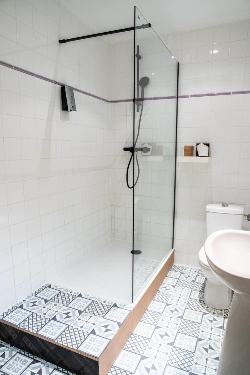 une douche avec une porte vitrée dans une salle de bain dans l'établissement Logis hôtel restaurant Auberge de l'Espinouse, à Fraisse-sur-Agout 50 autres photos