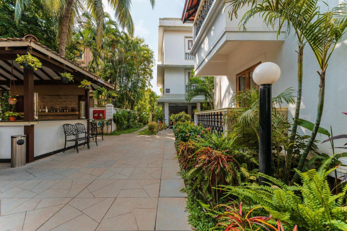 a walkway in front of a building with plants at Radisson Goa Candolim in Candolim
