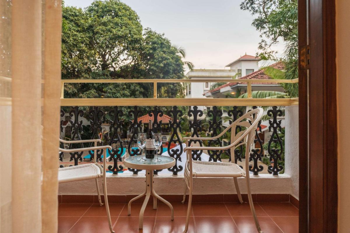 a balcony with a table and chairs and a window at Radisson Goa Candolim in Candolim