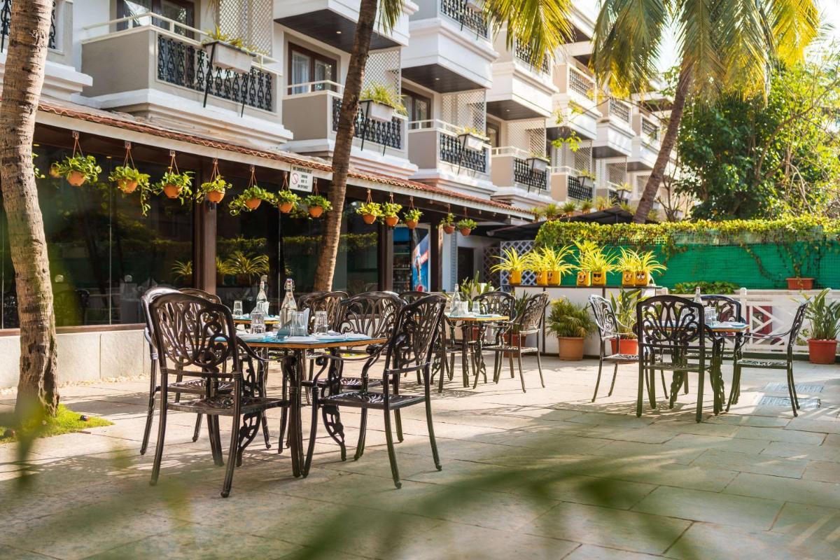 a group of tables and chairs in front of a building at Radisson Goa Candolim in Candolim