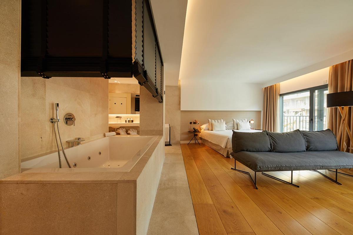 Un baño grande con cama y bañera. en Nakar Hotel, en Palma de Mallorca