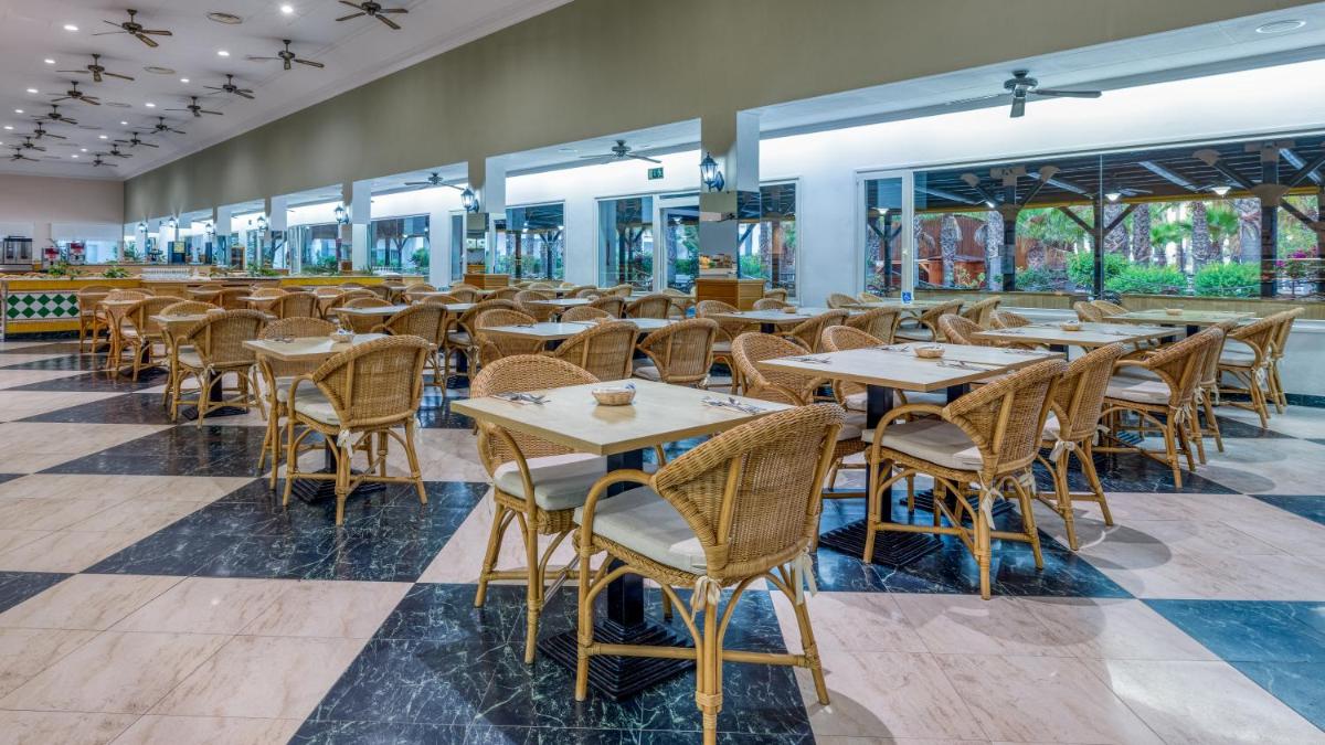 Un restaurante con mesas, sillas y ventanas. en Playaballena, en Costa Ballena