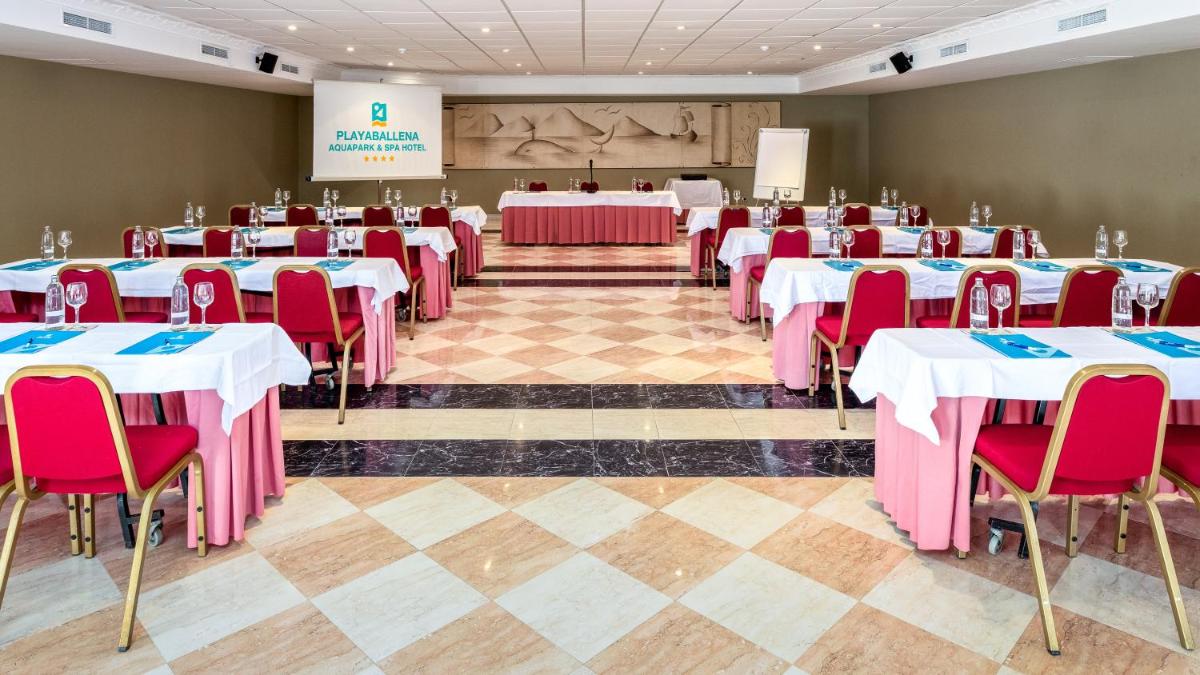 una sala de conferencias con mesas, sillas y un escenario en Playaballena, en Costa Ballena 43 fotos más