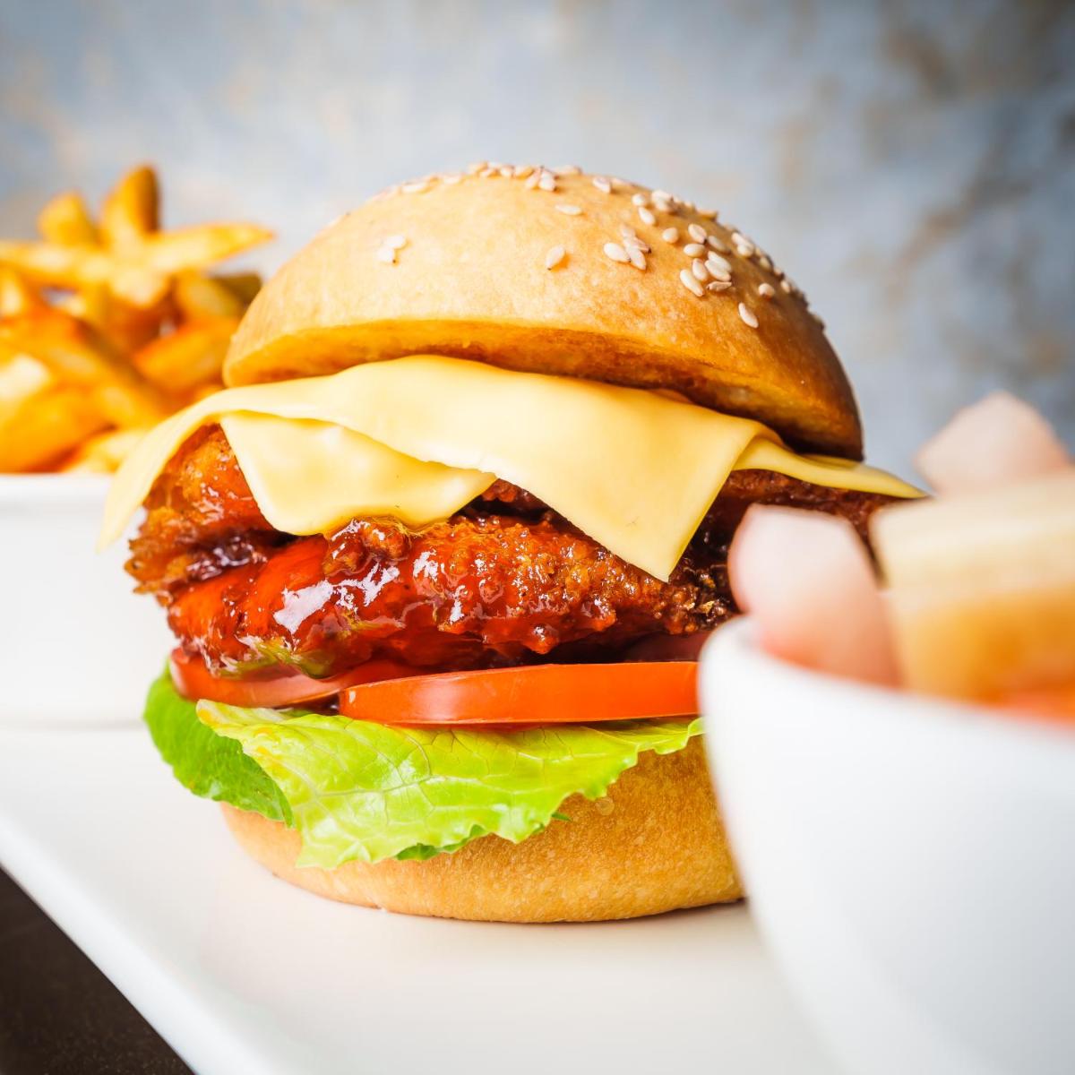 a cheeseburger with lettuce tomato and cheese and fries at Pharos Hotels in Chennai