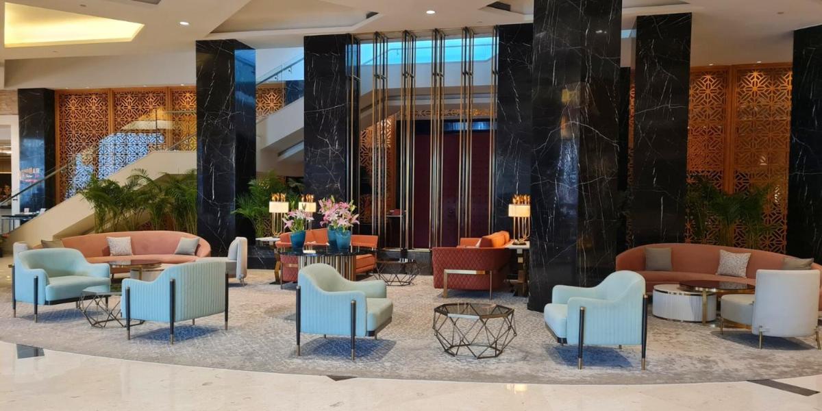 a lobby with blue chairs and tables at InterContinental Jaipur Tonk Road by IHG in Jaipur