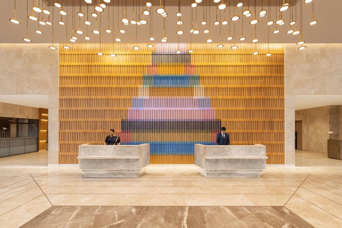 a lobby with two men in front of a colorful wall at Courtyard by Marriott Tiruchirappalli in Tiruchchirāppalli