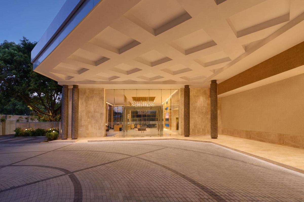 an empty lobby of a building with a large ceiling at Courtyard by Marriott Tiruchirappalli in Tiruchchirāppalli