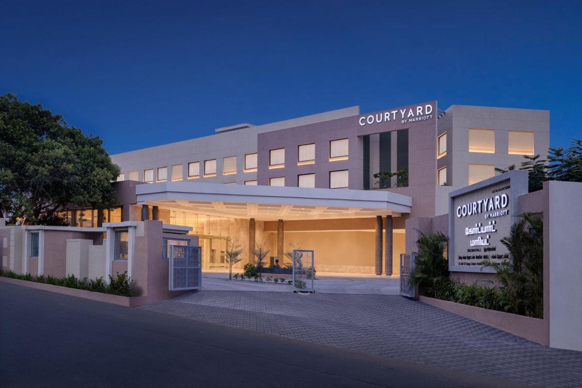 a large building with a sign in front of it at Courtyard by Marriott Tiruchirappalli in Tiruchchirāppalli