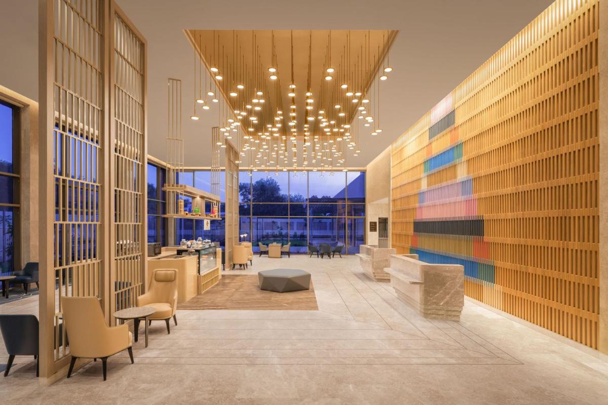 a lobby of a building with a chandelier at Courtyard by Marriott Tiruchirappalli in Tiruchchirāppalli