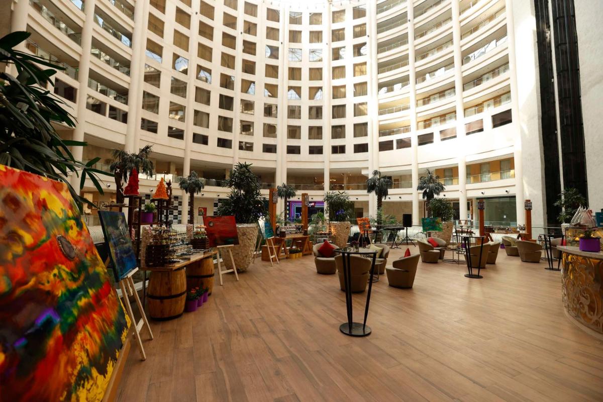 a large lobby with a large building with a lot of plants at Radisson Blu Hotel New Delhi Dwarka in New Delhi a large lobby with a large building with a lot of plants at Radisson Blu Hotel New Delhi Dwarka in New Delhi