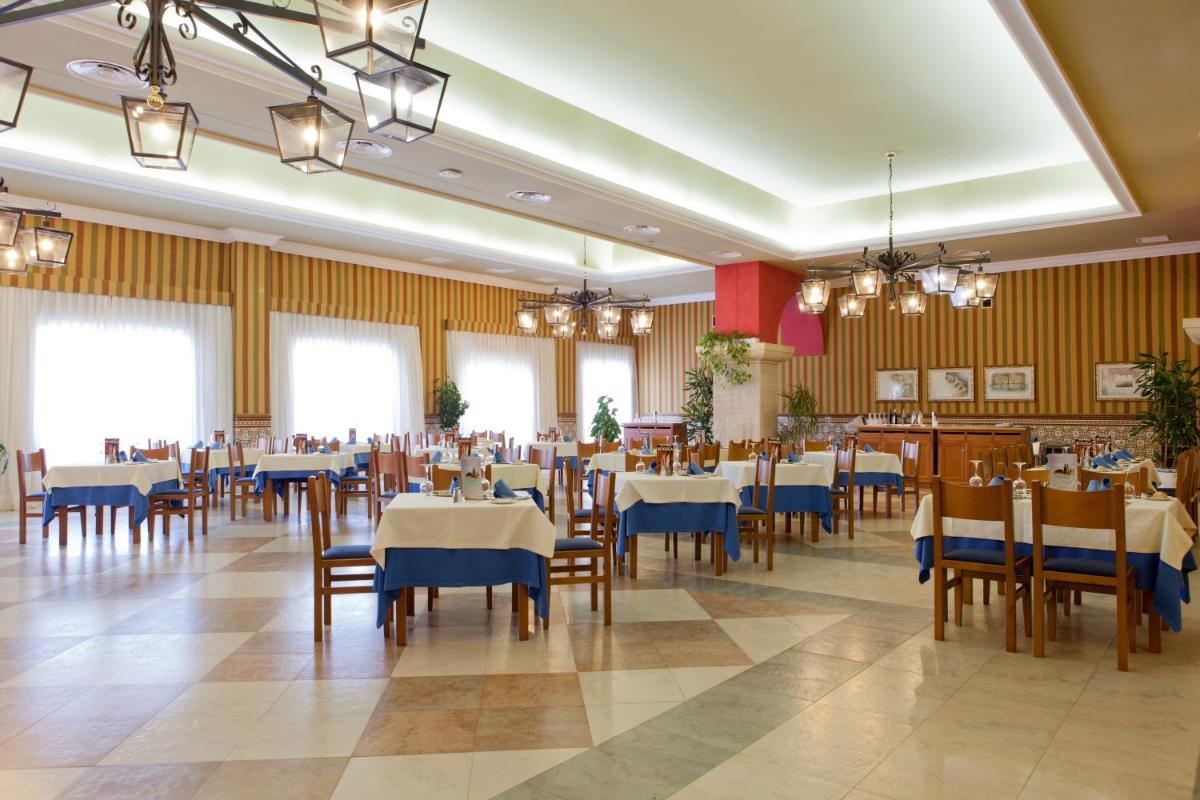 Un comedor con mesas y sillas en un restaurante. en Playacartaya, en El Portil