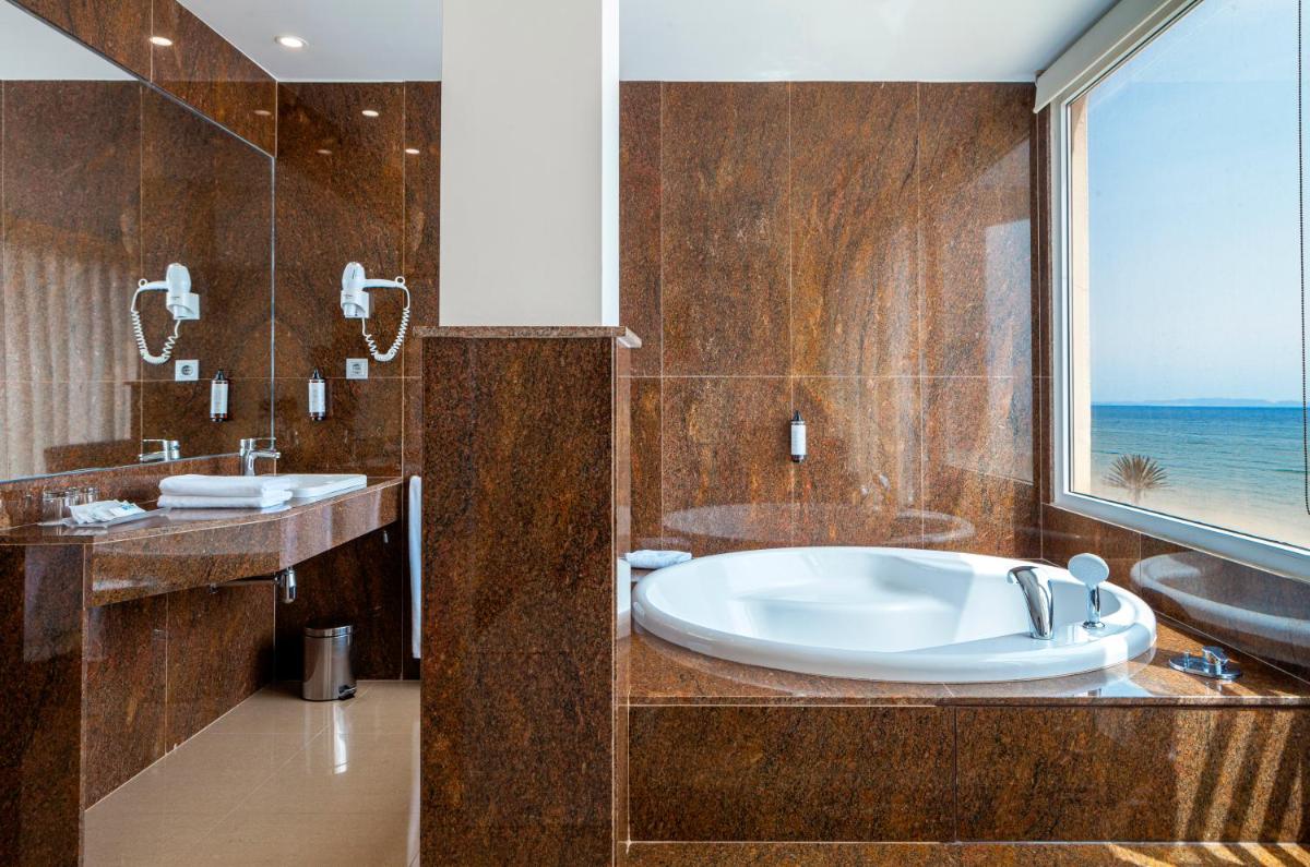 Un baño con bañera, lavabo y ventana. en Playasol, en Roquetas de Mar