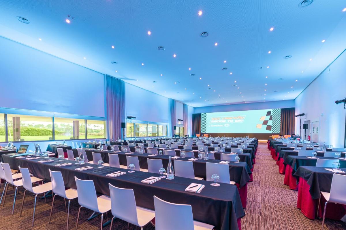uma sala de conferências com mesas e cadeiras e uma tela em Algarve Race Resort - Hotel em Montes de Cima mais 86 fotografias