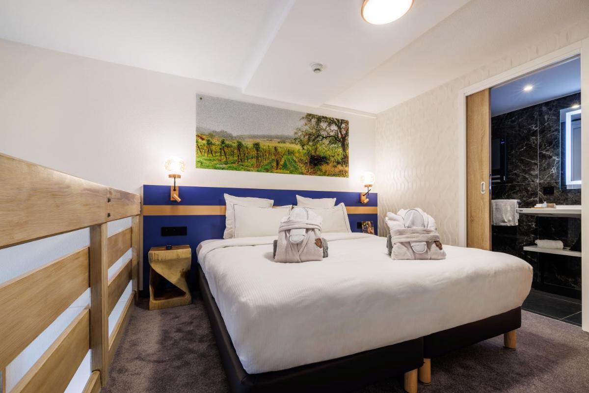 Un ou plusieurs lits dans un hébergement de l'établissement Hotel SPA Husseren Collections - Proche Colmar - Eguisheim