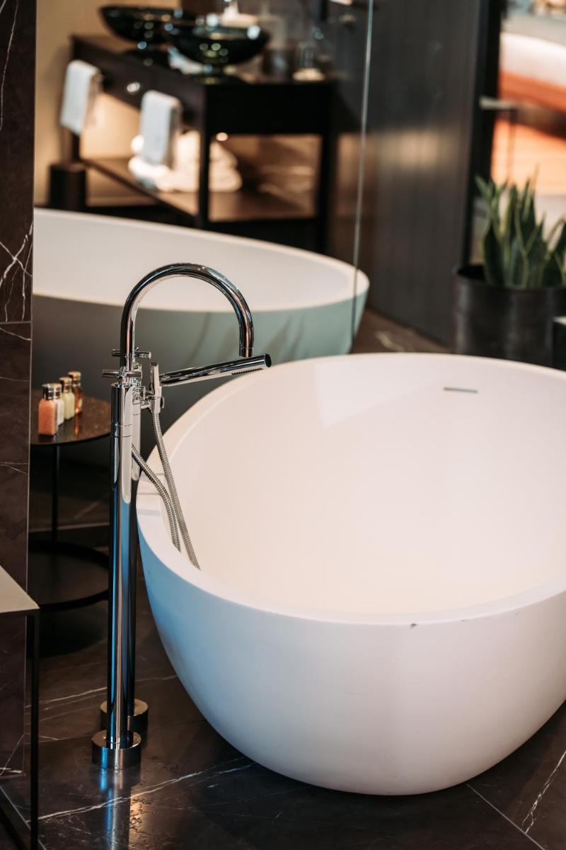 eine Badewanne mit einem Wasserhahn im Bad in der Unterkunft DO & CO Hotel München in München + 37 Fotos eine Badewanne mit einem Wasserhahn im Bad in der Unterkunft DO & CO Hotel München in München + 37 Fotos