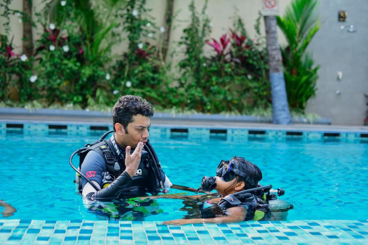 a man and a diver in a swimming pool at Holiday Inn Goa Candolim in Candolim a man and a diver in a swimming pool at Holiday Inn Goa Candolim in Candolim