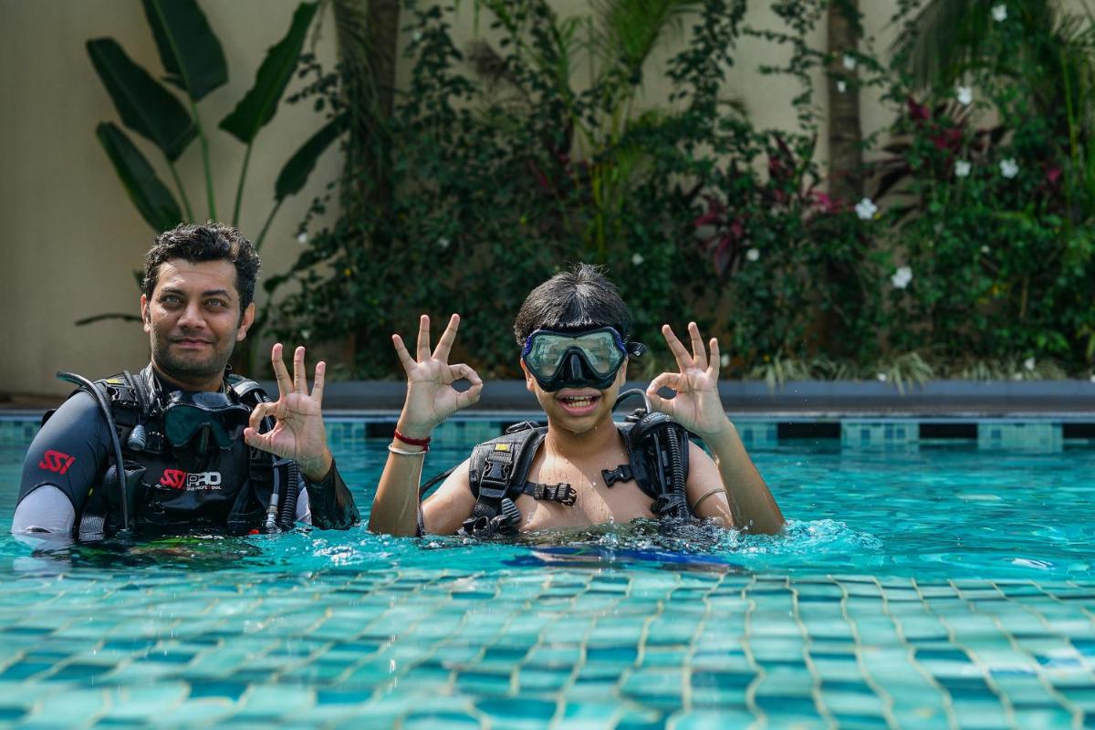 a man and a woman in a swimming pool at Holiday Inn Goa Candolim in Candolim a man and a woman in a swimming pool at Holiday Inn Goa Candolim in Candolim