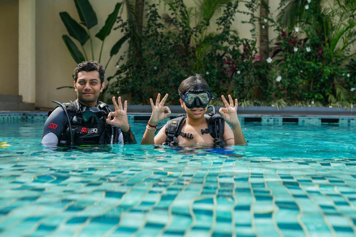 a man and a woman in a swimming pool at Holiday Inn Goa Candolim in Candolim a man and a woman in a swimming pool at Holiday Inn Goa Candolim in Candolim