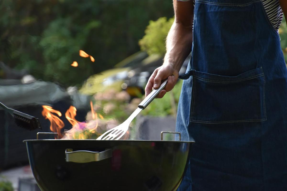 a man cooking food in a grill with a spatula at Holiday Inn Goa Candolim in Candolim a man cooking food in a grill with a spatula at Holiday Inn Goa Candolim in Candolim
