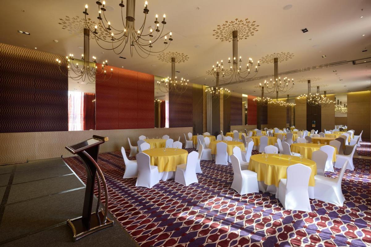 a banquet hall with yellow tables and white chairs at Marasa Sarovar Premiere in Tirupati