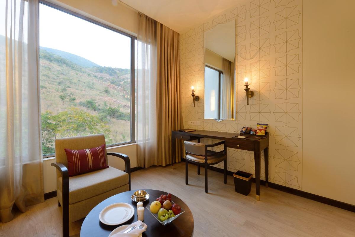 a hotel room with a table and a desk at Marasa Sarovar Premiere in Tirupati