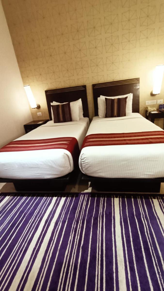 two beds sitting next to each other in a hotel room at Marasa Sarovar Premiere in Tirupati