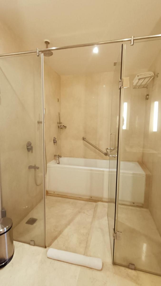 a bathroom with a shower and a bath tub at Marasa Sarovar Premiere in Tirupati