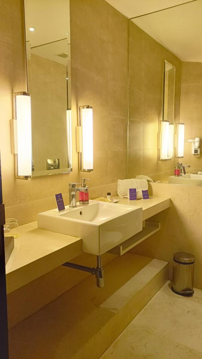 a bathroom with two sinks and a large mirror at Marasa Sarovar Premiere in Tirupati
