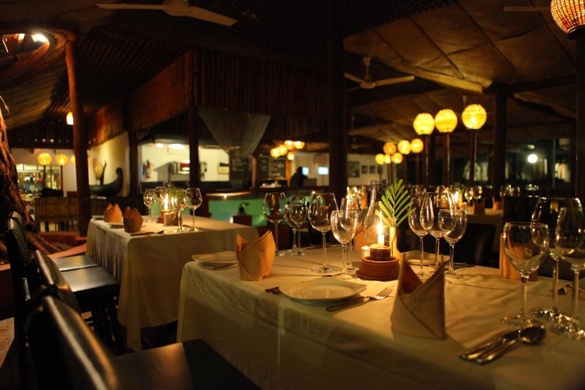 a dining room with several tables with wine glasses at Casino Hotel - CGH Earth, Cochin in Cochin