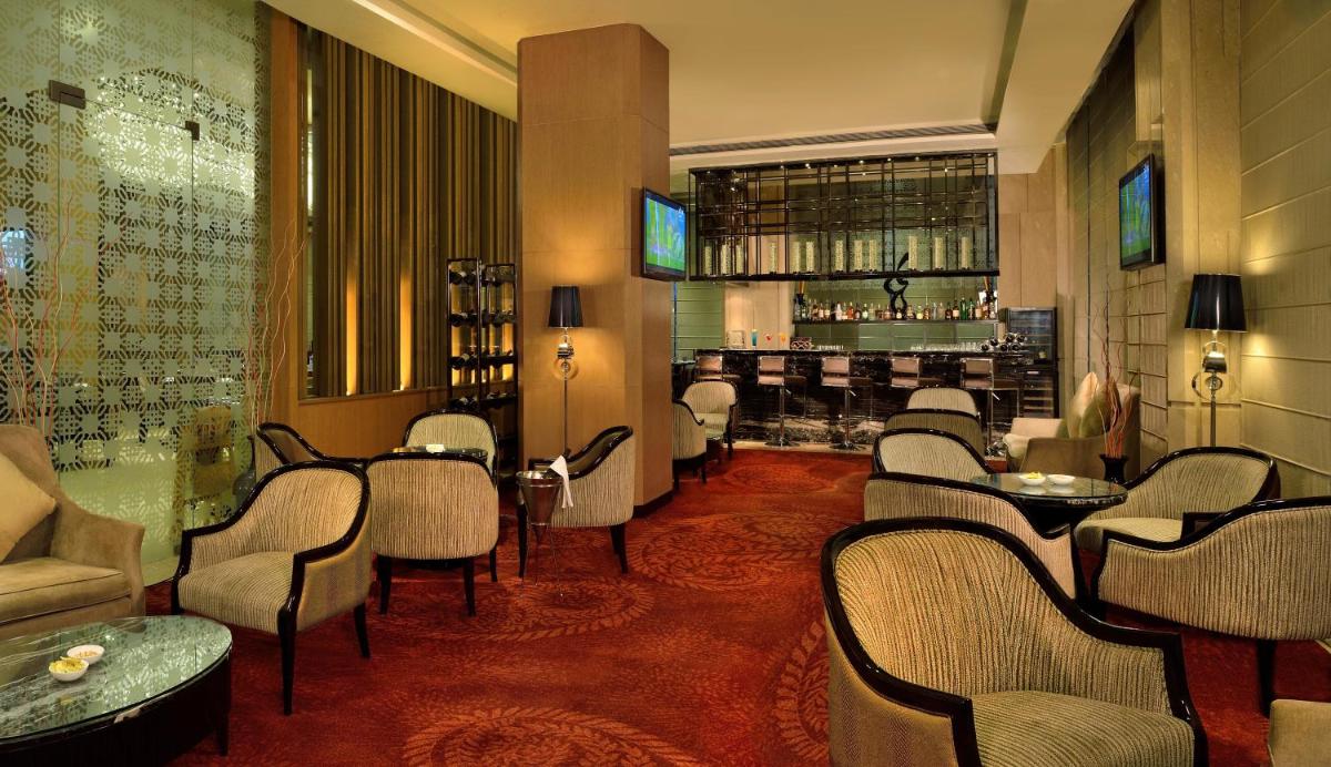 a bar with chairs and tables in a room at Radisson Blu Jaipur in Jaipur