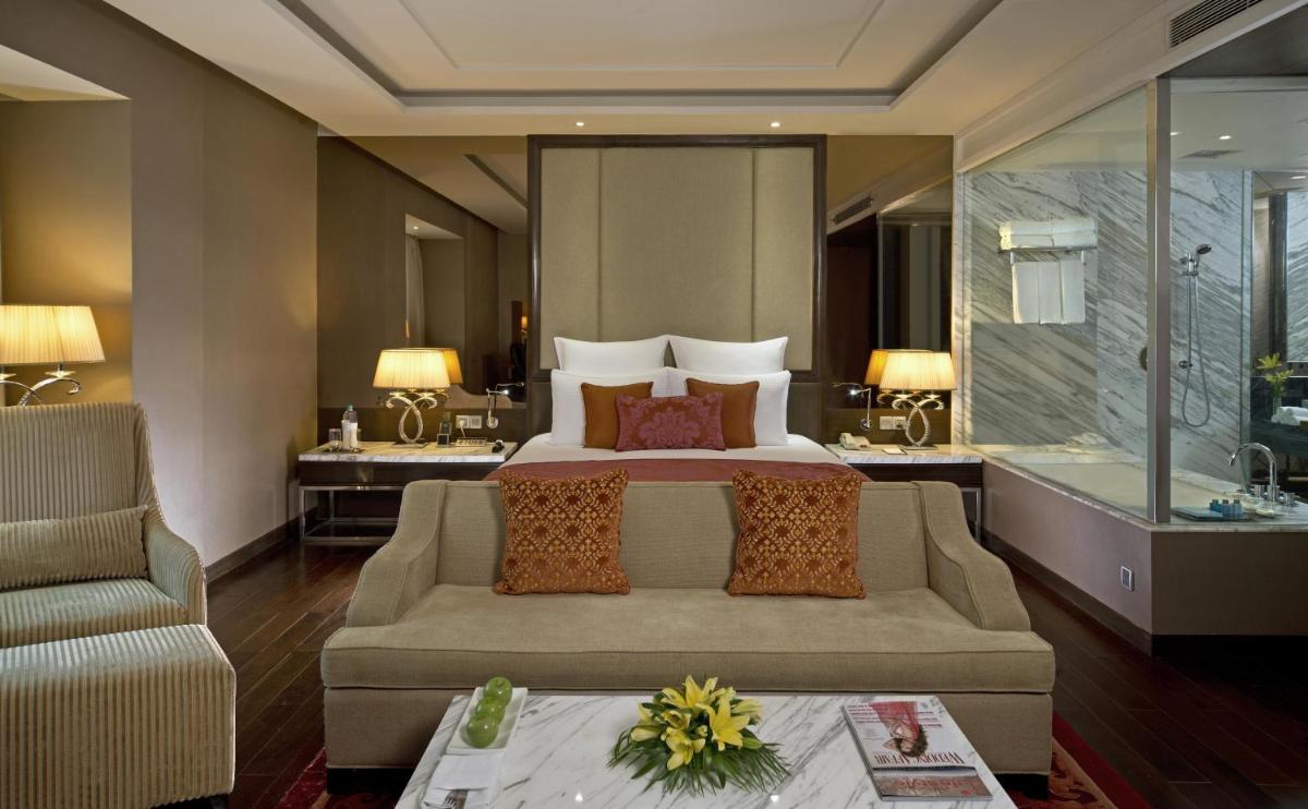 a hotel room with a bed and a couch at Radisson Blu Jaipur in Jaipur