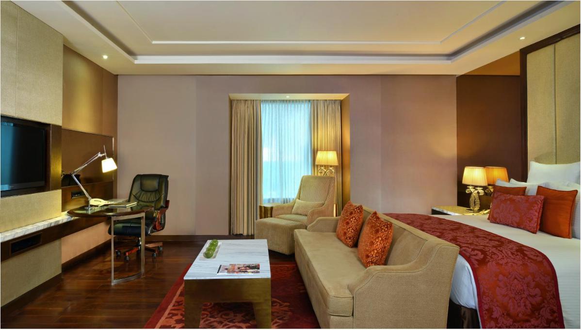a hotel room with a bed and a couch at Radisson Blu Jaipur in Jaipur