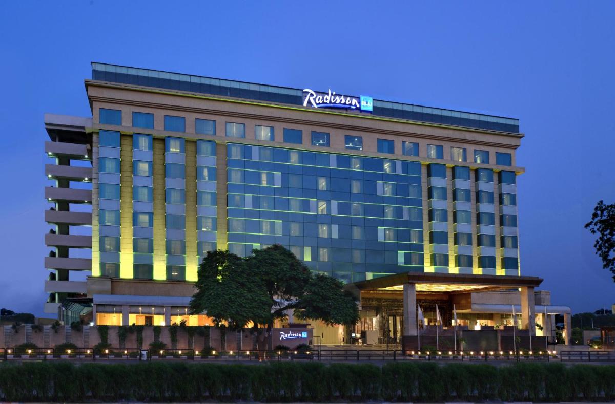 a hotel with a sign on the top of it at Radisson Blu Jaipur in Jaipur