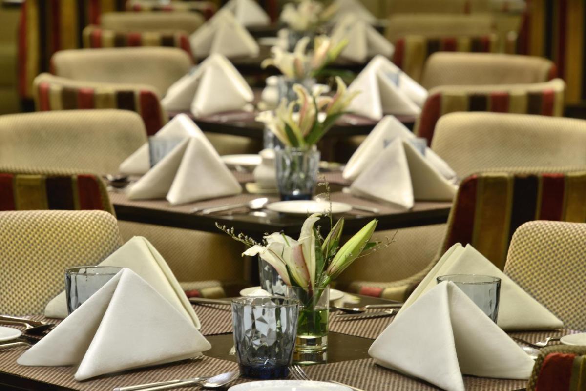 a set of tables with white napkins on them at Radisson Blu Jaipur in Jaipur