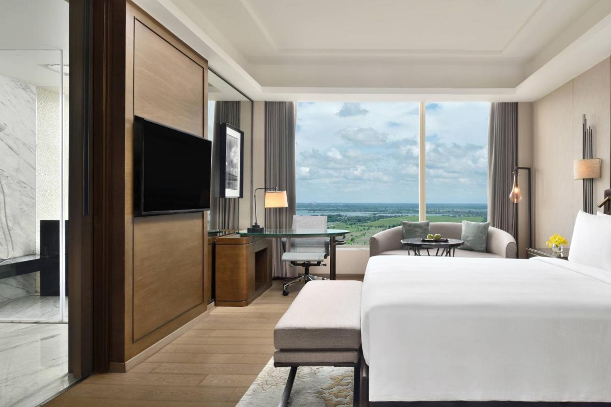a hotel room with a bed and a living room at JW Marriott Hotel Kolkata in Kolkata