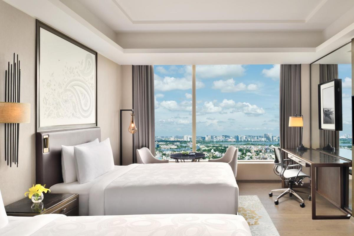 a hotel room with a bed and a desk and a window at JW Marriott Hotel Kolkata in Kolkata
