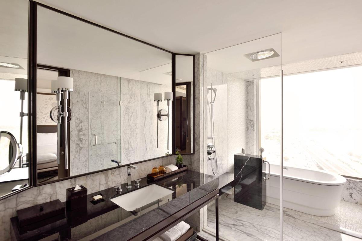 a bathroom with a tub and a sink and a mirror at JW Marriott Hotel Kolkata in Kolkata