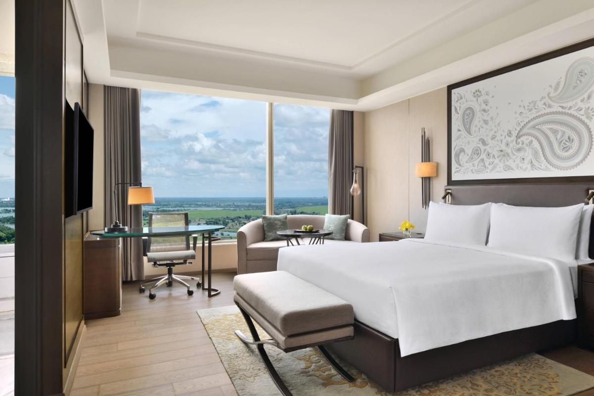 a bedroom with a large white bed and a desk at JW Marriott Hotel Kolkata in Kolkata