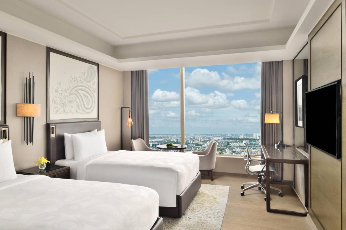 a hotel room with two beds and a desk at JW Marriott Hotel Kolkata in Kolkata
