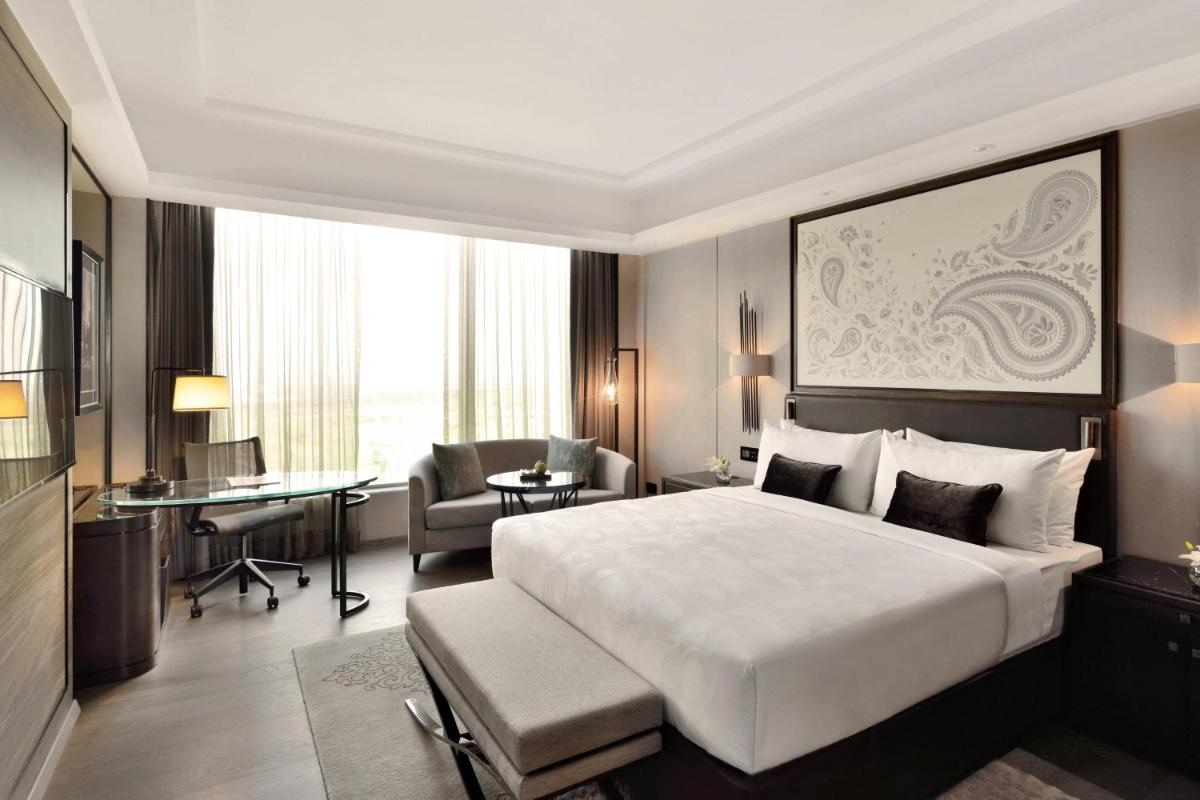 a hotel room with a large bed and a desk at JW Marriott Hotel Kolkata in Kolkata