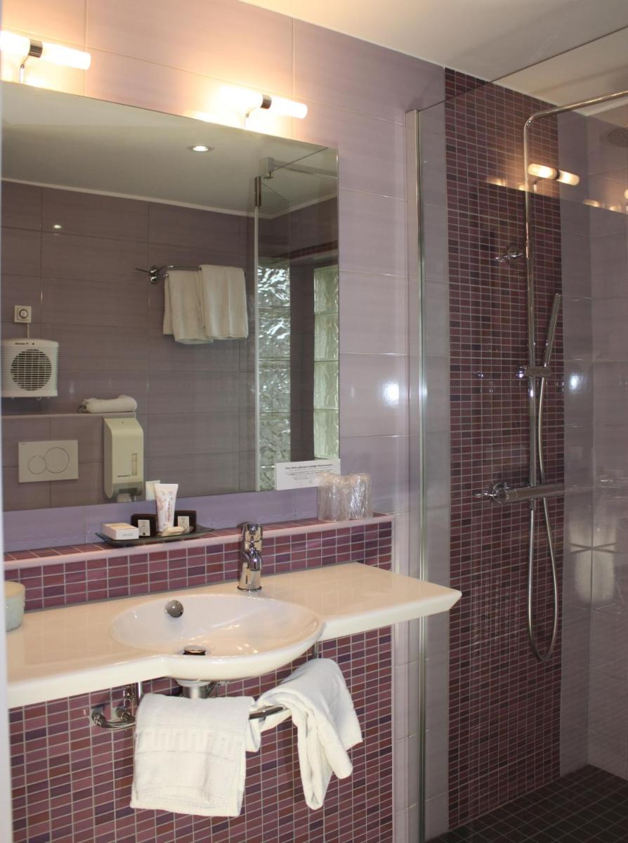 une salle de bain avec un lavabo, une douche et un miroir dans l'établissement Hôtel Restaurant Taillard, à Goumois 35 autres photos