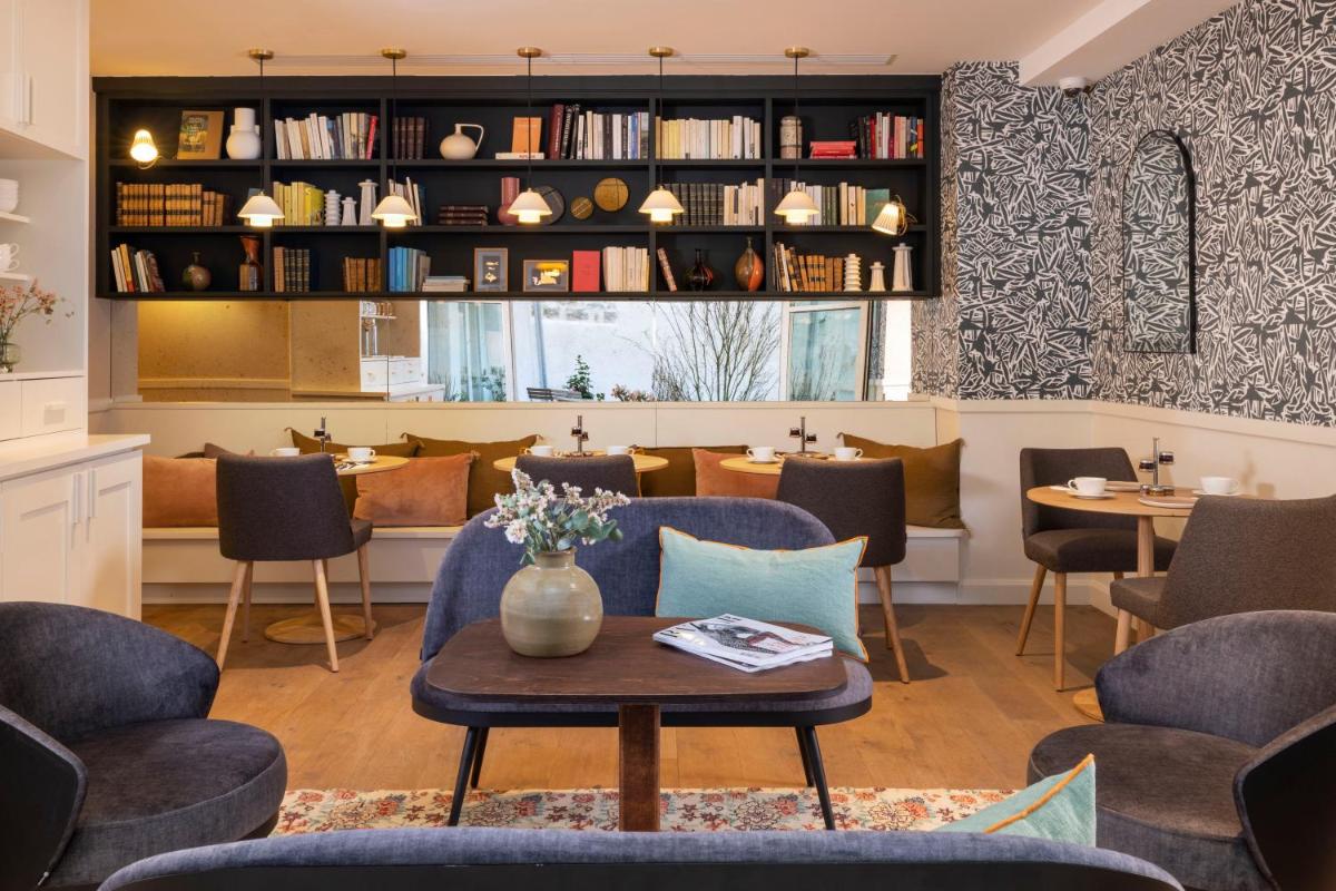 - un restaurant avec des tables et des chaises bleues dans l'établissement Le Petit Oberkampf Hotel & Spa, à Paris