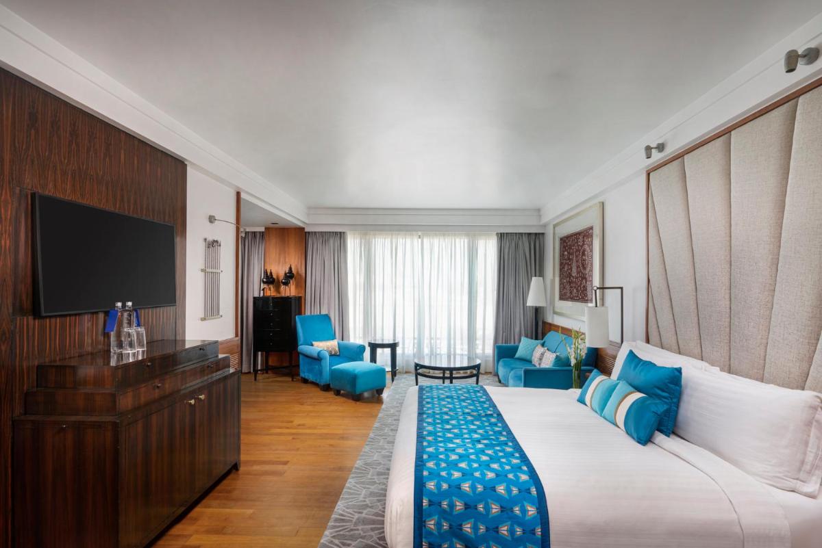 a hotel room with a large bed and a television at InterContinental Marine Drive Mumbai by IHG in Mumbai