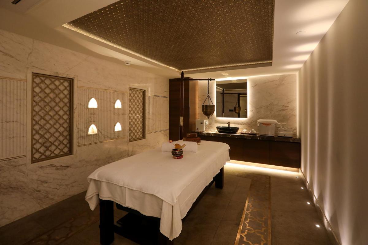 a dining room with a table and a kitchen at Radisson Blu Hotel & Suites GRT Chennai in Chennai