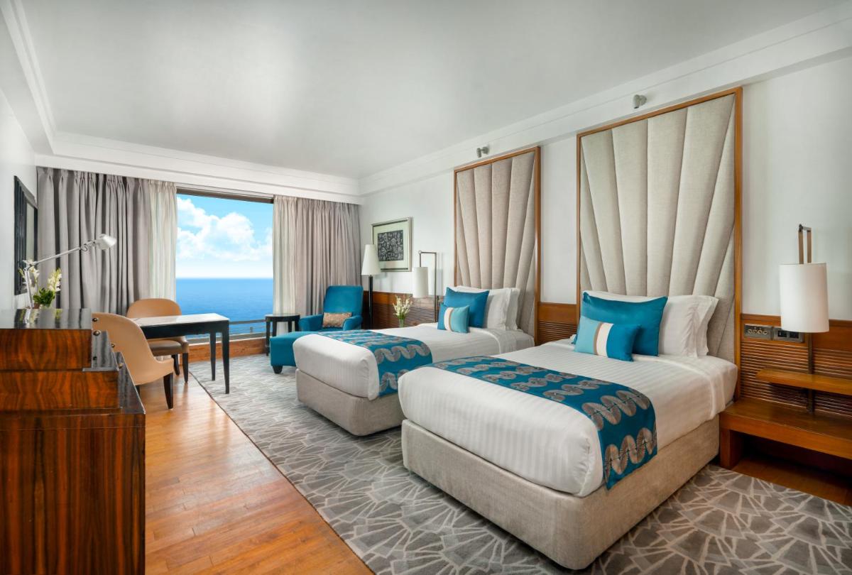 a hotel room with two beds and a desk at InterContinental Marine Drive Mumbai by IHG in Mumbai a hotel room with two beds and a desk at InterContinental Marine Drive Mumbai by IHG in Mumbai