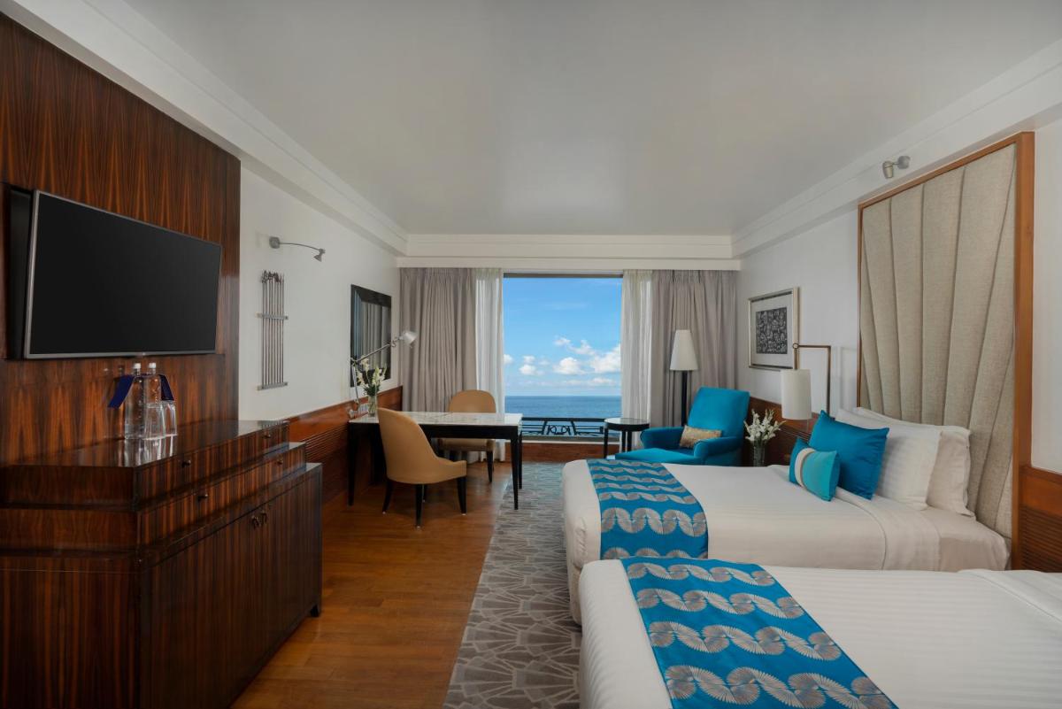 a hotel room with two beds and a television at InterContinental Marine Drive Mumbai by IHG in Mumbai