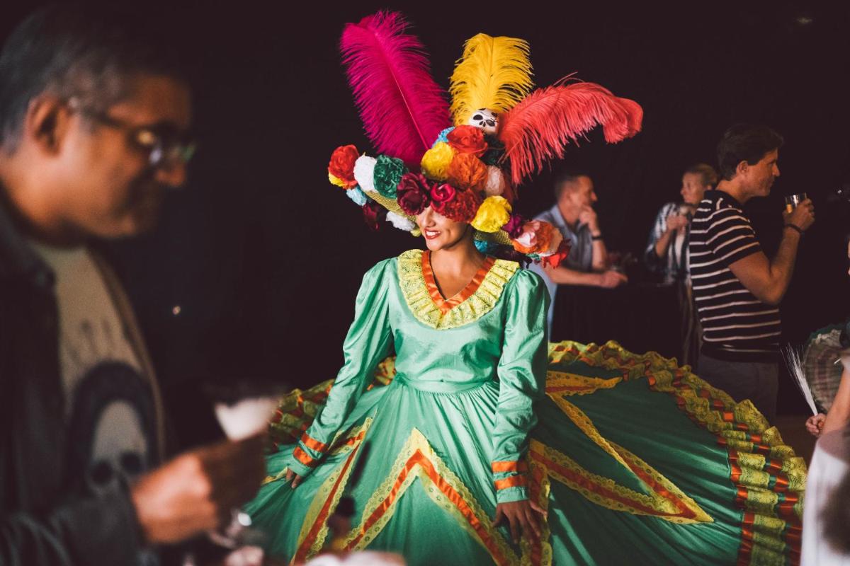Una mujer con un vestido verde con un pájaro en la cabeza en Princesa Yaiza Suite Hotel Resort, en Playa Blanca